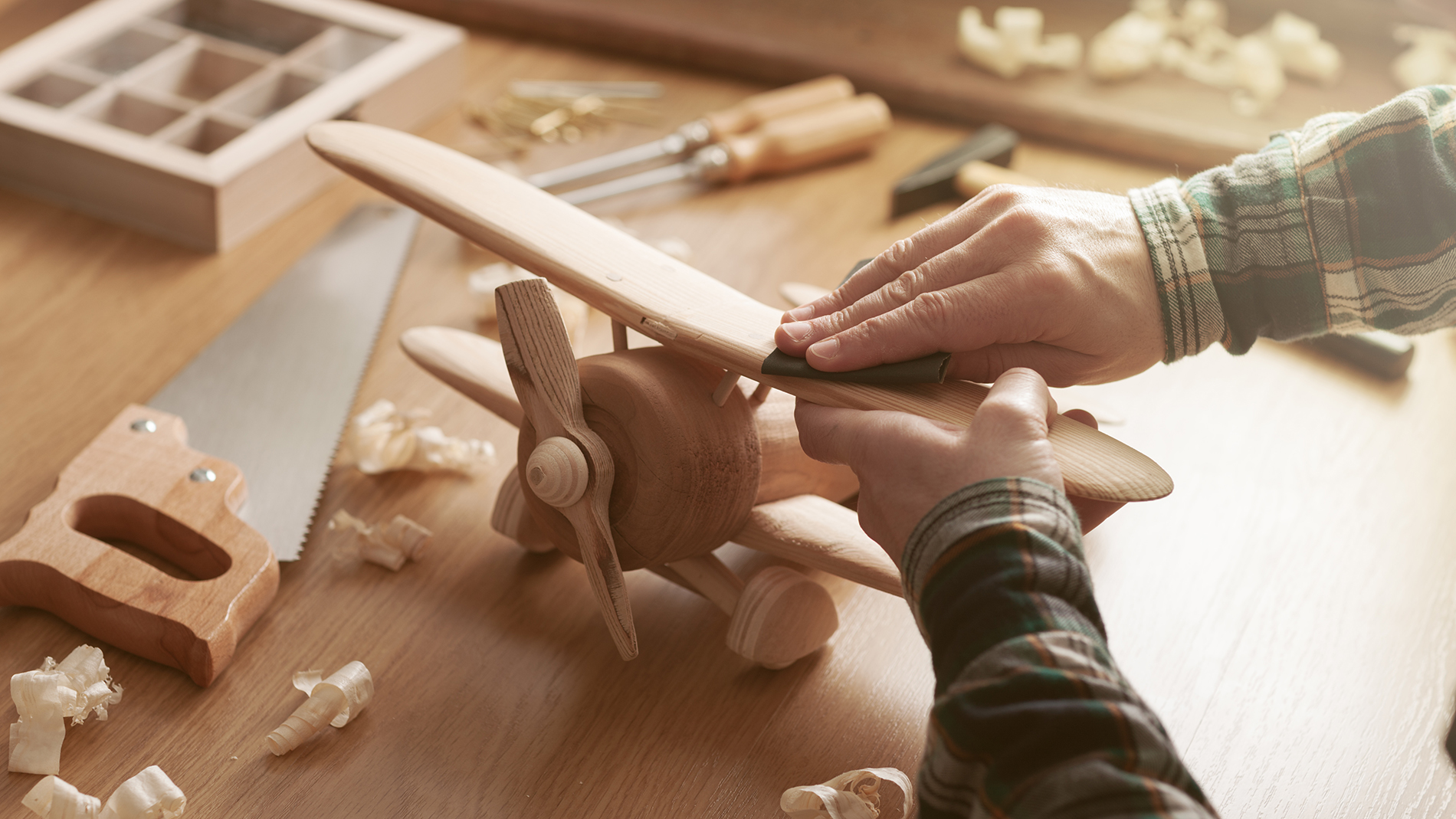 Craftsman building a wooden toy airplane