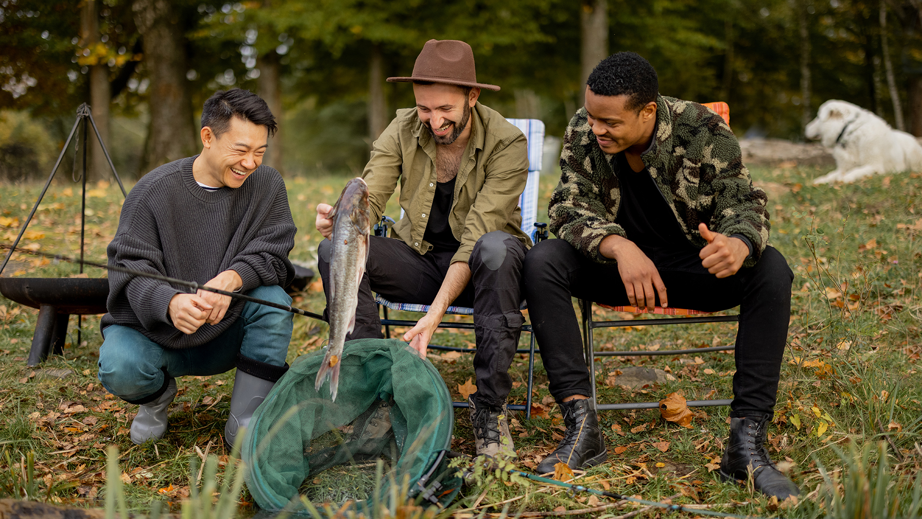 Male friends look catch in fishing net at fishing