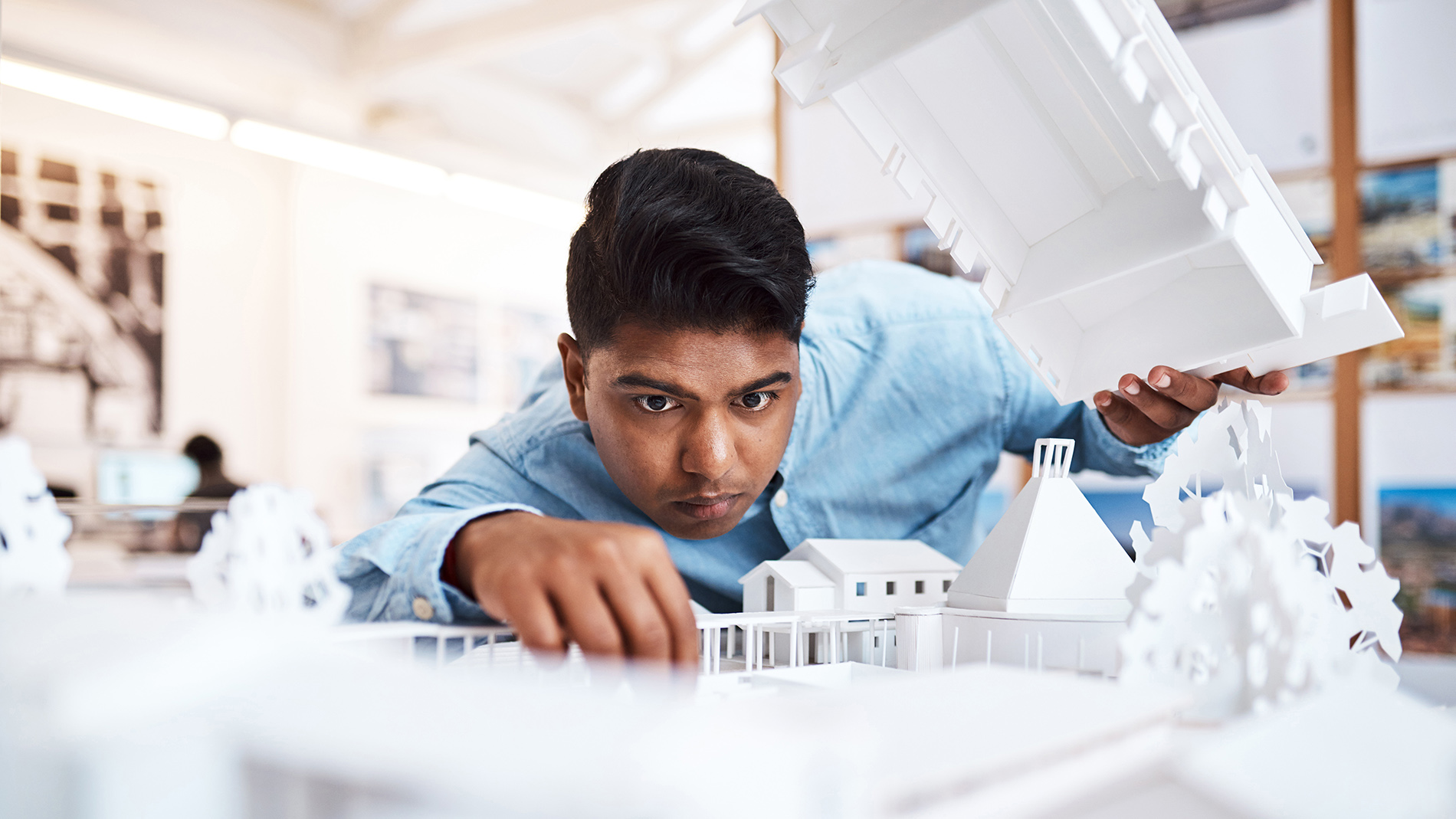 Shot of a young architect designing a building model in a modern office